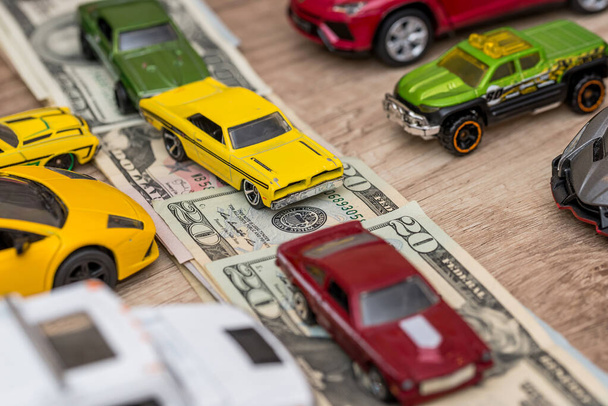 many toy cars on dollar as road - Фото, изображение