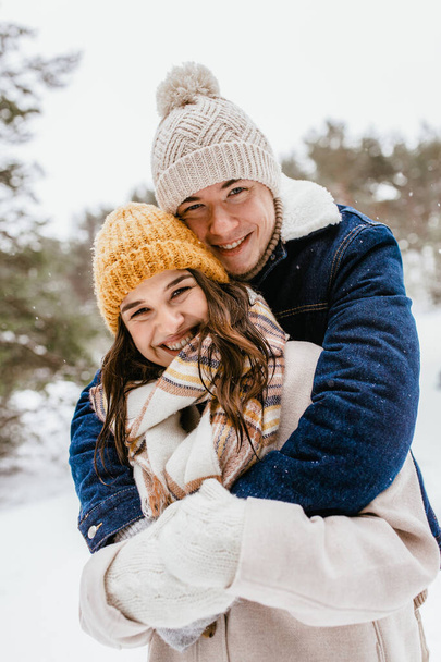people, love and leisure concept - happy smiling couple hugging in winter park - Foto, imagen