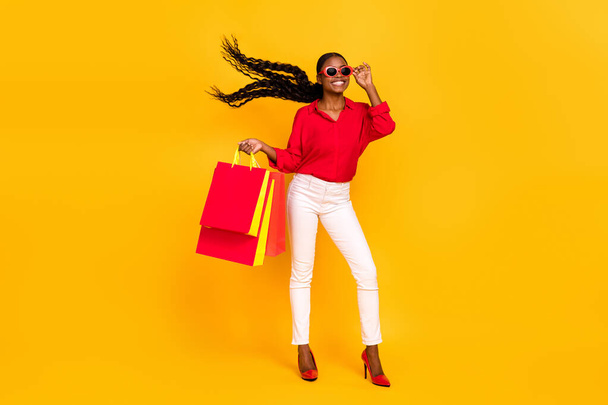 Full body photo of young cheerful girl shopping mall store discount eyeglasses isolated over yellow color background. - Фото, изображение