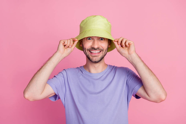 Photo of joyful guy arm finger touch fashionable headwear ready have rest sea time vacation summer relax isolated on pink color background. - Photo, image
