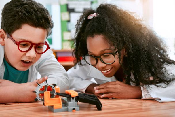 Can you believe we built this. an adorable little boy and girl building a robot in science class at school - Photo, image
