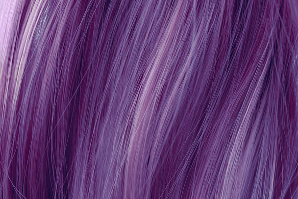 Purple curly hair texture closeup. Toned purple  hair background. - Photo, image