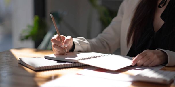 Крупним планом перегляд жіночої руки, що пише на блокноті з олівцем. Копіювати простір
 - Фото, зображення