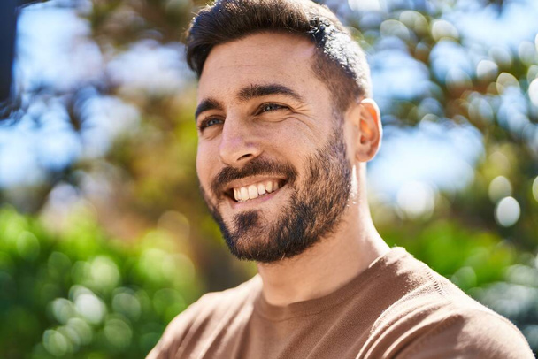 Jeune homme hispanique souriant confiant debout au parc - Photo, image