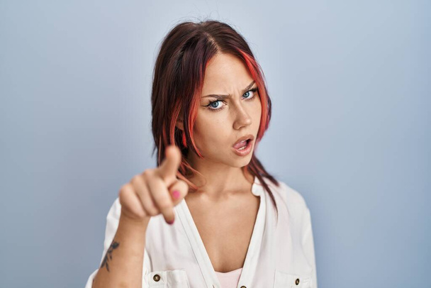 Young caucasian woman wearing casual white shirt over isolated background pointing displeased and frustrated to the camera, angry and furious with you  - Photo, Image