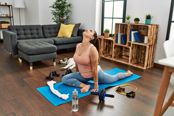 Jeune femme souriant entraînement confiant yoga à la maison - Photo, image