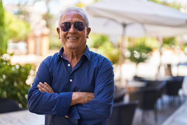 Senior grey-haired man smiling confident standing with arms crossed gesture at street - Photo, Image