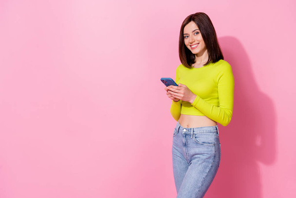 Photo of funky pretty girl dressed lime shirt chatting modern device empty space isolated pink color background. - Foto, immagini