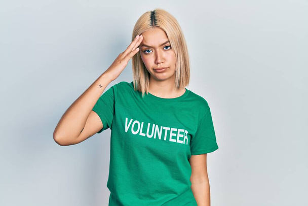 Beautiful blonde woman wearing volunteer t shirt worried and stressed about a problem with hand on forehead, nervous and anxious for crisis  - Photo, Image