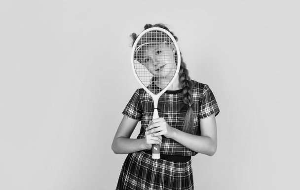 Relaxing after training. happy girl holding sport equipment. kid hold tennis racket. child wear fitness cap. childhood activity. healthy way of life. be energetic. badminton player with racquet. - Фото, зображення