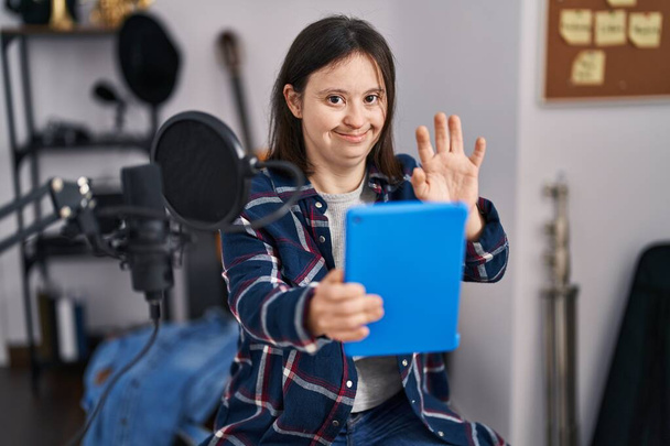 Nuori nainen alas oireyhtymä muusikko hymyilee luottavainen ottaa videopuhelu musiikkistudiossa - Valokuva, kuva