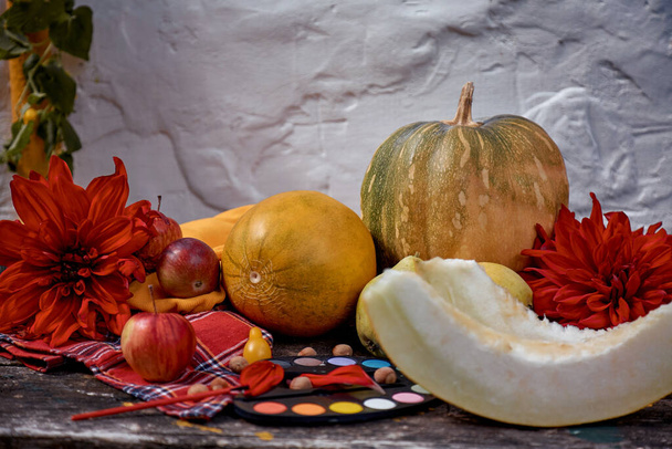Φθινοπωρινή αισθητική έκθεση: κίτρινα φρούτα και λαχανικά και φωτεινά χρώματα με ένα πινέλο, κολοκύθα, αχλάδια, μήλο και πεπόνι. Η ιδέα της ημέρας των Ευχαριστιών. Φθινοπωρινή νεκρή φύση με κόκκινη Τζορτζίν, σύγχρονες σκιές. Υψηλής ποιότητας φωτογραφία - Φωτογραφία, εικόνα