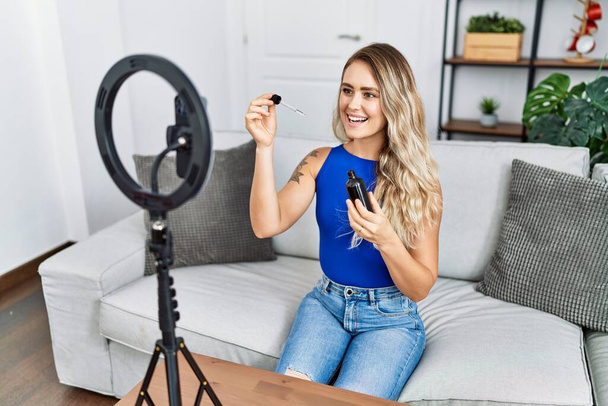 Young woman recording skin care tutorial by smartphone at home - Fotografie, Obrázek