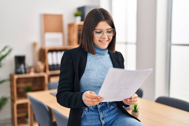Young beautiful hispanic woman business worker reading document at office - Fotoğraf, Görsel