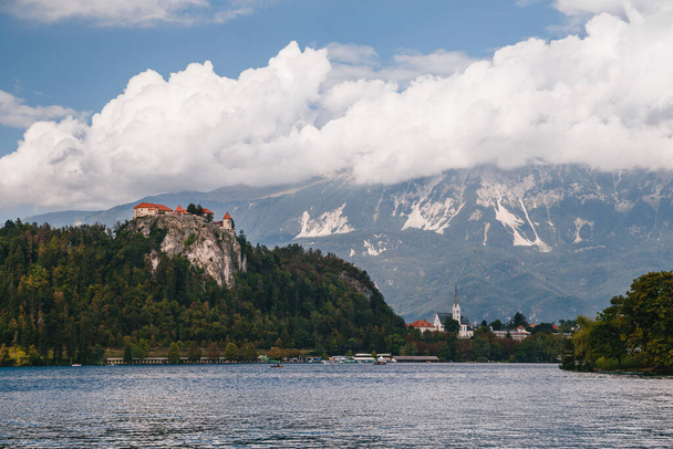 Close up view of the Bled Castle, the Bled city, St. Martin's Parish Church, parks and beaches situated on the bank of the Lake Bled, surrounded by forest and mountains. Travel concept - Fotoğraf, Görsel