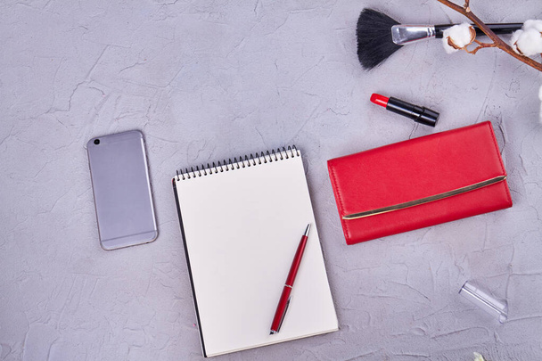 Top view flat lay womans workspace with blank notepad. Smartphone with purse and lipstick. - Valokuva, kuva