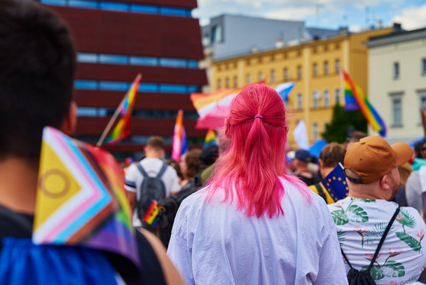 People crowd with LGBTQ rainbow flags on pride parade. Tolerance, diversity and gender identity concept - 写真・画像