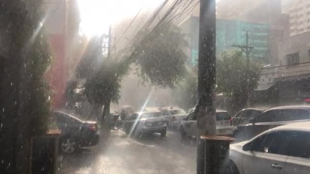 Giet regen tijdens zonnige dag in de stad Zon douche stoep - Video