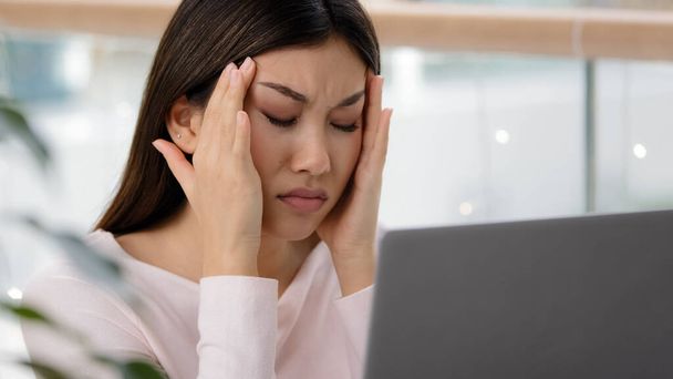 Close up headshot Asiático coreano senhora doente chinês menina estressante mulher de negócios sentindo dor de cabeça cansado trabalhador exausto estudante feminino com laptop sofrendo desconforto tensão cabeça estresse - Foto, Imagem