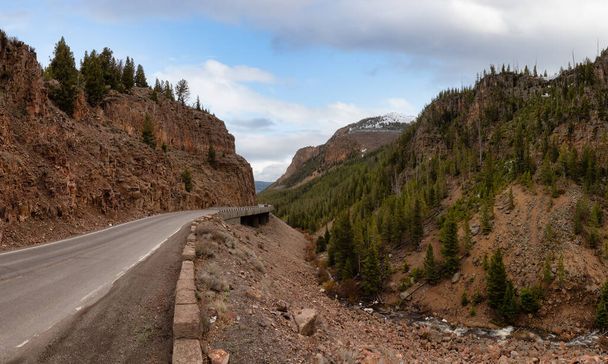 Scenic Road in the American Landscape. Yellowstone National Park, Wyoming. Cloudy Sky Art Render. United States. Nature Background Panorama - 写真・画像