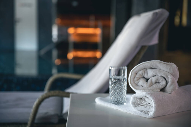 Spa background with a glass of water and towels in a spa complex, copy space. - Foto, Bild