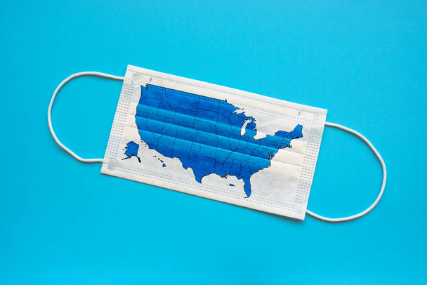 Medical protective mask and map of USA on it as a symbol of quarantine. - Φωτογραφία, εικόνα