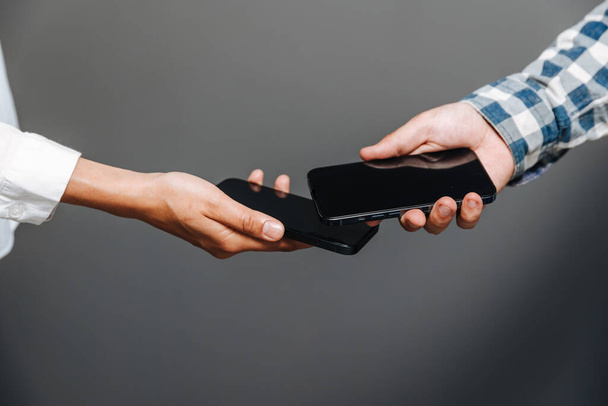Horishni Plavni, Ukraine - 07. Juni 2022: Tippen Sie auf zu bezahlen. Mann und Frau mit iPhone als Zahlungsterminal, kontaktloses Bezahlkonzept, ios 16 - Foto, Bild