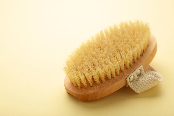 Brush for dry anti-cellulite massage or brushing on beige background. Beauty concept. - Fotoğraf, Görsel