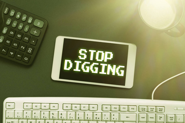 Sign display Stop Digging, Concept που σημαίνει πρόληψη παράνομης εκσκαφής λατομείο Περιβάλλον Διατήρηση Κινητό τηλέφωνο με νέο μήνυμα στο γραφείο με πληκτρολόγιο, αριθμομηχανή και καφέ. - Φωτογραφία, εικόνα