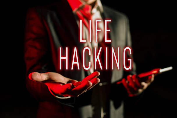 Text sign showing Life Hacking, Business idea Simple and clever techniques in accomplishing task easily Businessman In Suit Holding New Important Message In One Hand. - Foto, Imagen