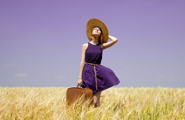 rude dziewczyny z walizka w polu pszenicy wiosna. - Zdjęcie, obraz