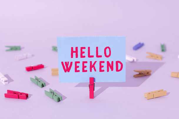 Writing displaying text Hello Weekend, Concept meaning Getaway Adventure Friday Positivity Relaxation Invitation Important Message Presented On Piece Of Paper Clipped With Clip. - 写真・画像