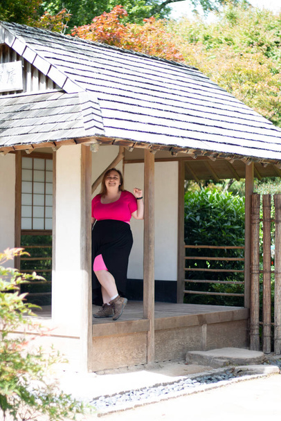 Plus size woman exploring a Japanese style building while on a travel adventure - Fotó, kép