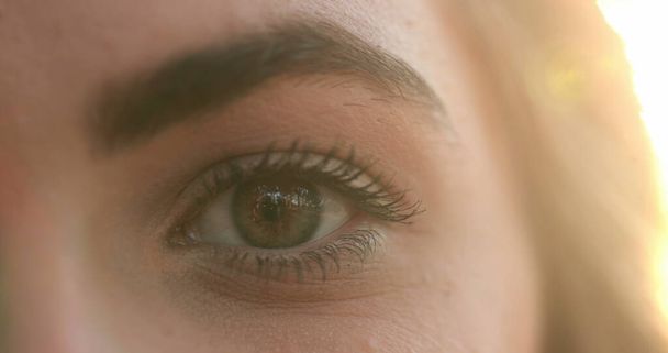 Macro close-up of young woman eyes in the sunlight with flare, opening and closing eyes meditating and contemplation - Foto, Imagem