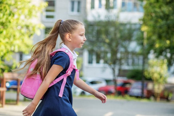 Krásná holčička s růžovým batohem chodí do školy. Koncept návratu do školy, vzdělávání a dětství - Fotografie, Obrázek