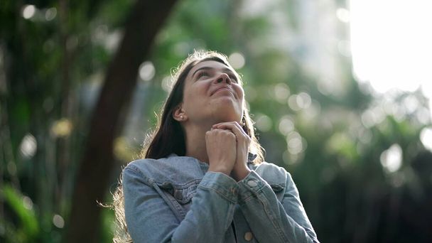 Onnellinen nainen on kiitollinen. Hengellinen tyttö rukoilee katsoen SKY kanssa HOPE - Valokuva, kuva