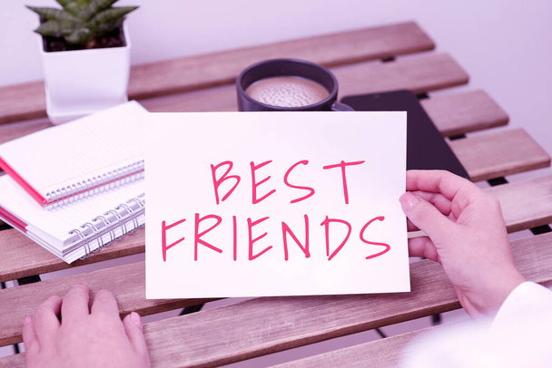 Εγγραφείτε εμφανίζοντας Best Friends, Business βιτρίνα Ένα πρόσωπο που αξία πάνω από άλλα πρόσωπα Για πάντα τους φίλους κάθεται Επιχειρηματίας κρατώντας σημαντικό μήνυμα σε χαρτί στο τραπέζι. - Φωτογραφία, εικόνα