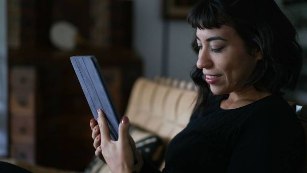 One south american latin woman looking at tablet content online at home living room - Photo, Image