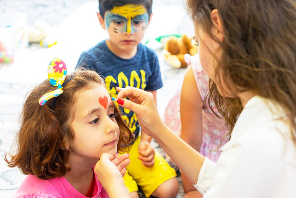 BAKU,AZERBAIJAN- 13 MAY 2019 : Girl draws little girl aqua makeup. Face painting. Children leisure - Foto, Bild