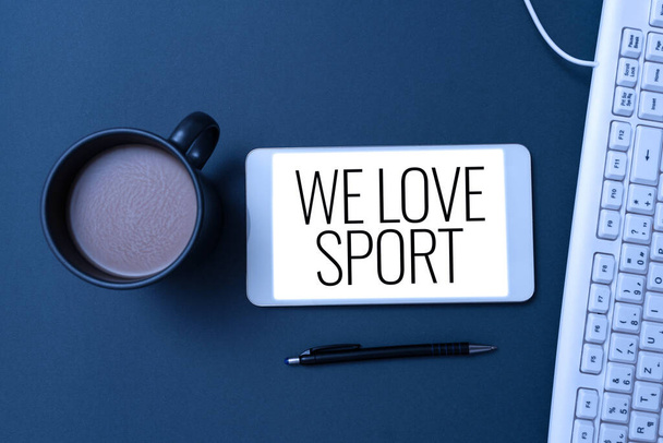 Hand writing sign We Love Sport, Word Written on To like a lot practicing sports athletic activities work out Phone Screen With Important Message On Desk With Keyboard, Pen And Coffee. - Photo, Image