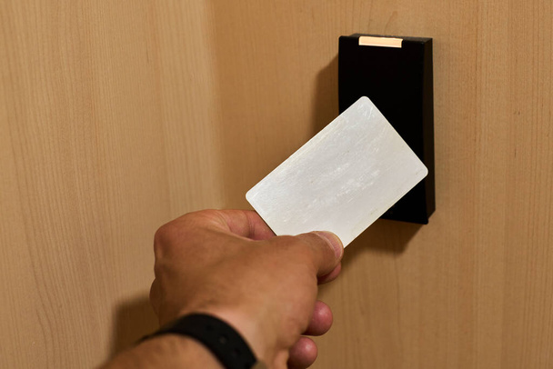 Hand approaching a card to an rfid reader to open a security door. High quality photo - Fotó, kép