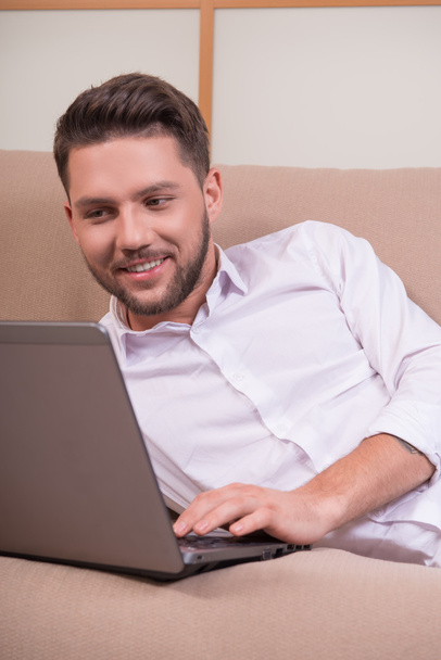 Komea mies kannettavan tietokoneen kanssa
 - Valokuva, kuva