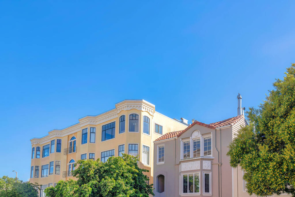 Вікторіанська багатоквартирна будівля і середземноморський сірий будинок в Сан-Франциско, Каліфорнія. Зліва є квартира з віконними поручнями поруч з будинком справа з рефлективними вікнами.. - Фото, зображення
