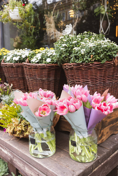 Tulips, heather, chrysanthemum and hanging flowers and wreaths at the flower shop. Halloween and Thanksgiving autumn decoration with flowers in trendy rattan baskets - Foto, imagen