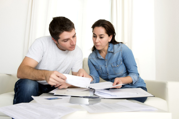 pareja joven preocupada en casa en la contabilidad de estrés pagos bancarios
  - Foto, Imagen