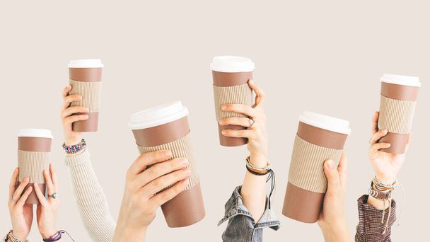 Many different arms raised up holding coffee cup - Photo, image
