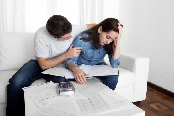Jeune couple inquiet à la maison dans le stress mari réconfortant femme dans des problèmes financiers
 - Photo, image