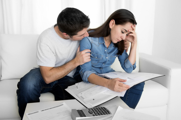 Jeune couple inquiet à la maison dans le stress mari réconfortant femme dans des problèmes financiers
 - Photo, image