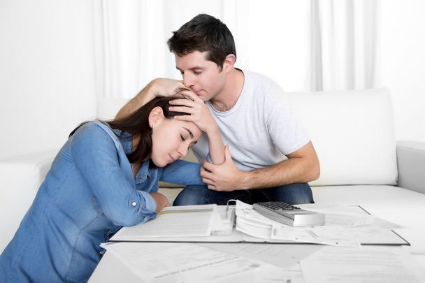 Pareja joven preocupada casa en estrés marido reconfortante esposa en problemas financieros
 - Foto, imagen