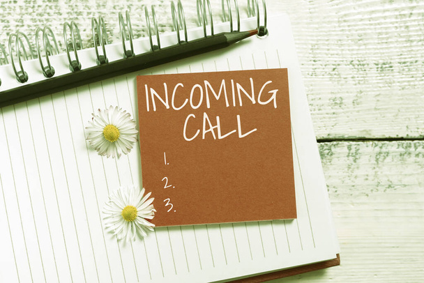 Conceptual display Incoming Call, Business concept Inbound Received Caller ID Telephone Voicemail Vidcall Sticky Note With New Ideas Over Notebook With Pencil And Flowers Around. - Photo, Image